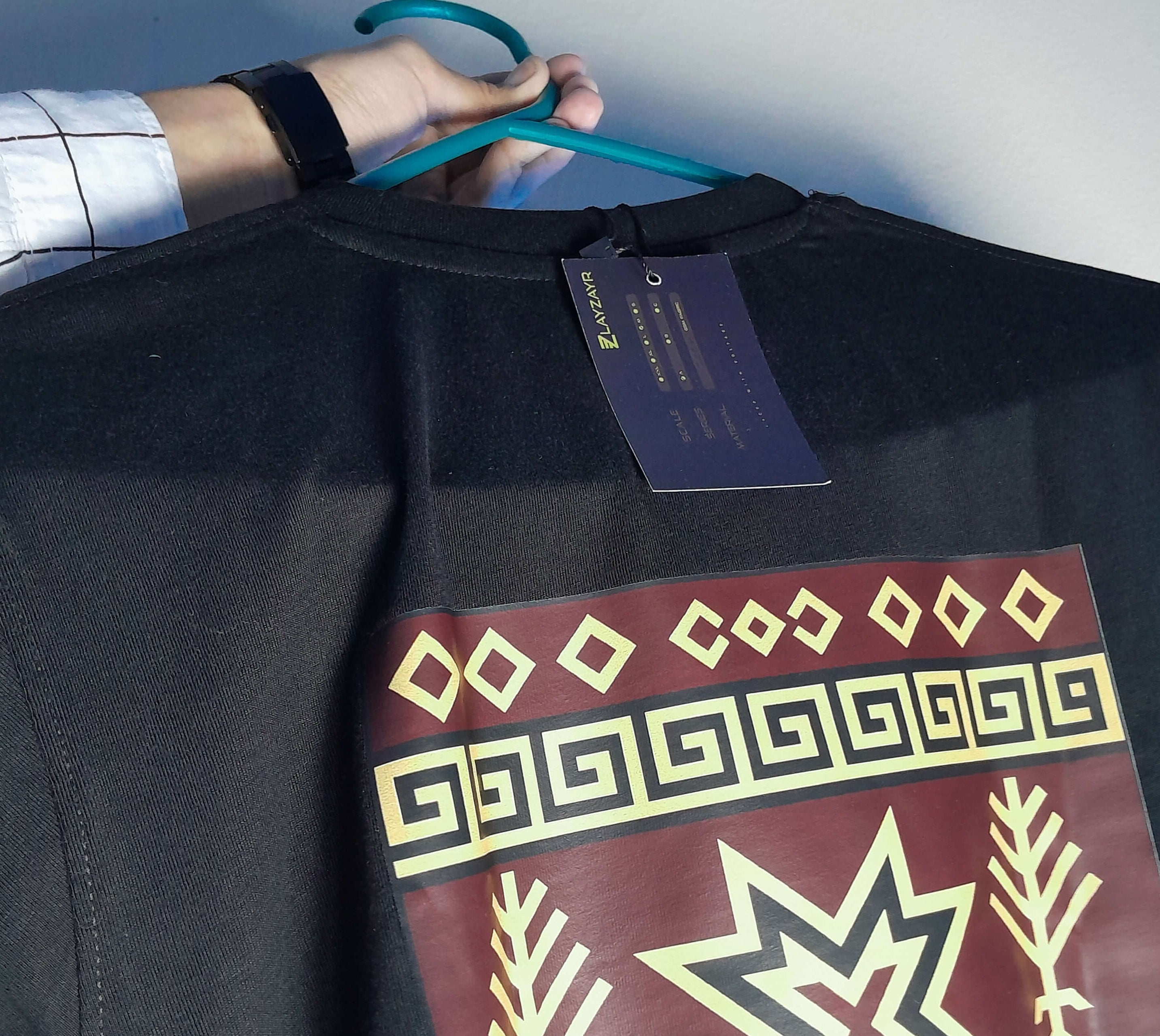 Black sweatshirt with a star design held by a person, brand 'LAYZAYR' visible