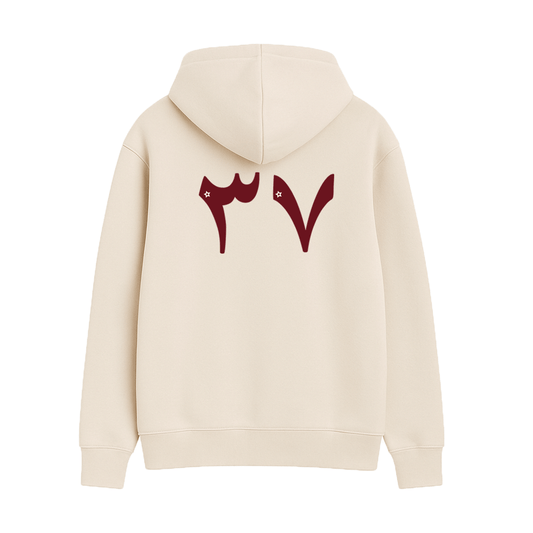 Beige hoodie with red Arabic designs on the back against a white background