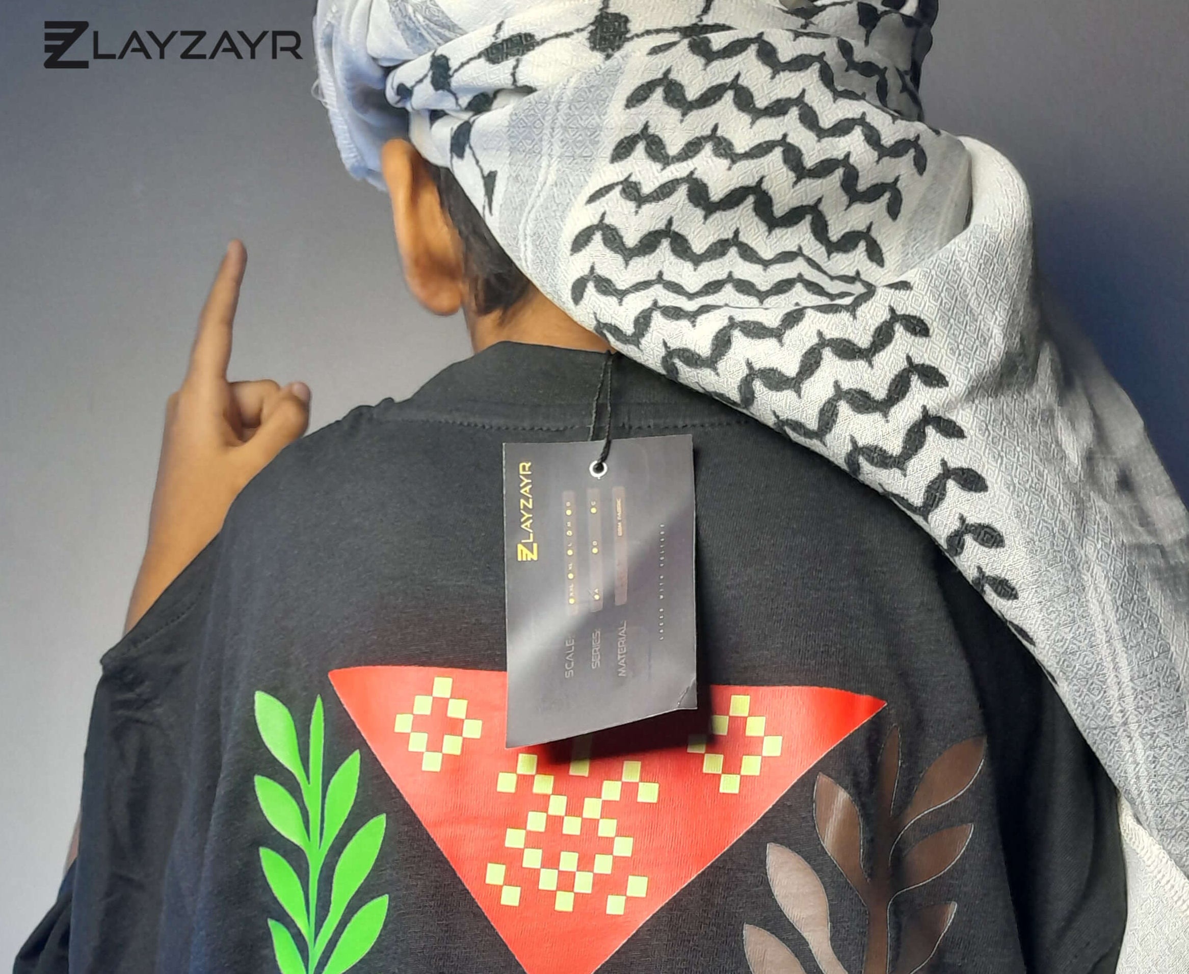 Person wearing a black garment with colorful leaf patterns and a Zlayzayr tag.